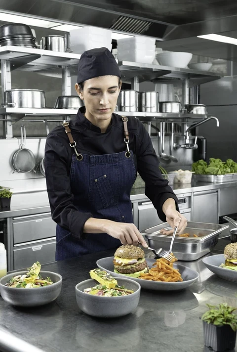 Kucharz przygotowujący burgera w kuchni restauracji