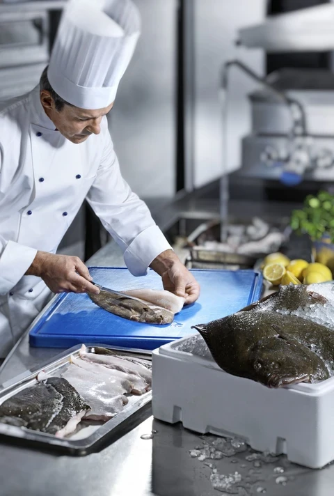 Profesjonalny kucharz przygotowujący danie ze świeżej ryby