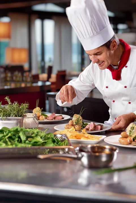 Kucharz w profesjonalnej kuchni przyrządza danie z wołowiną